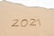 Happy New Year 2021 text on the sandy beach. Welcoming 2021 with new resolutions, dreams concept