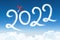 Happy New year 2022 concept on the background below cloudscape. Drawing by passenger light-engine, turboprop airplane white vapor