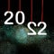 Happy New Year 2022. White numbers hanging on red twine. Fireworks on background