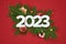 Happy New Year 2023 banner with candy, fir brunches and christmas element. Festive red background with realistic