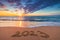 Happy New Year 2023 concept, lettering on the beach. Written text on the sea beach at sunrise