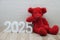 Happy New Year 2025 festive background with teddy bear decoration on wooden background