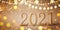 Happy New Year celebration background with golden numbers 2021 and Christmas decorations from lights and sparkles