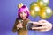 Happy new year celebration moments of excited young woman with pink haircut making selfie portrait on violet background