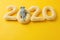 Happy New year concept. 2020 knitted yallow numbers with the symbol of the year the rat on a yellow background. Seasonal funny