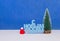 Happy New Year congratulation in Russian language with christmas tree and red cap on blue background