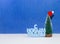 Happy New Year congratulation in Russian language with christmas tree in red cap on blue background