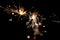 Happy New Year, Glittering burning sparkler against black night background