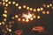 Happy New Year. Glowing sparklers in hands on background of golden christmas tree lights, couple celebrating in dark festive room