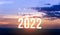 Happy New Year greeting card 2022, Happy New Year 2022 letters on the mountain with sunset on mountains landscape in twilight time