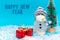 Happy New Year inscription snowman wearing protective mask on a blue background with presents.Front view