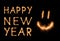 HAPPY NEW YEAR lettering and happy weird smiling smiley drawn with bengali sparkles isolated on black