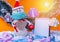 Happy New Year`s snowman in a red hat and protective mask stands by a notepad. Orange background.