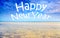 Happy New Year text over seascape