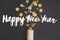 Happy New Year text sign on modern creative firework flat lay. Golden confetti popping from festive wrapping paper on black