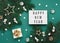 Happy New Year text on white Lightbox with gift box, holiday silver and gold decorations, acorns on green Christmas tree branches