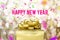 Happy new year word with Golden gift box with ribbon and colorful confetti at blur gold boekh light background,Winter holiday