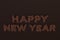 Happy New Year words from chocolate balls on chocolate background