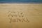 Happy New Year written in the golden sand of Little Kaiteriteri beach