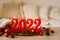 Happy New Years 2022. Numbers of year 2022 made by red candles on bokeh festive sparkling background