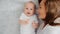 Happy newborn baby with his mother. Healthy newborn baby in a white t-shirt with mom. Closeup Faces of the mother and infant baby