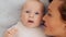 Happy newborn baby with his mother. Healthy newborn baby in a white t-shirt with mom. Closeup Faces of the mother and infant baby