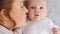 Happy newborn baby with his mother. Healthy newborn baby in a white t-shirt with mom. Closeup Faces of the mother and infant baby