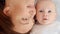 Happy newborn baby with his mother. Healthy newborn baby in a white t-shirt with mom. Closeup Faces of the mother and infant baby