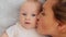 Happy newborn baby with his mother. Healthy newborn baby in a white t-shirt with mom. Closeup Faces of the mother and infant baby