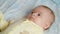 Happy newborn baby lying on the bed.