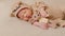Happy newborn baby weaing cute Mouse costume lying sleeps and hug doll on Beige background comfortable and safety.Cute Asian