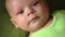 Happy newborn baby yawns closeup in white bed