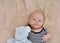 Happy newborn boy with toy wearing in stripped clothing