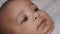 Happy newborn dark skin baby smiling on the blanket. Close up