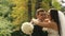 Happy newlywed bride and groom kissing, realizing that they are married now. Outdoor shot with summer park as background