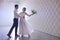 Happy newlywed couple dancing in festive hall