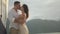 Happy newlywed couple kisses standing on sailing yacht deck