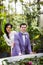 Happy newlywed couple posing in botanique garden, surrounded by