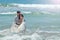 Happy newlyweds hug and laugh in the waters of the Indian Ocean. sunny wedding day and honeymoon in the tropics on the island