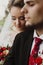 Happy newlyweds portrait, romantic couple, blonde bride with bouquet and handsome groom in stylish black suit posing outdoors, be