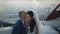 Happy newlyweds spending time on a sailboat in the open water together. Groom tenderly whispers in bride ear.