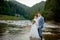 Happy newlyweds standing and smiling on the river . Honeymooners, photo for Valentine`s Day