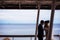 Happy newlyweds under the canopy by the seashore.