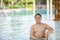 Happy obese boy sit on chair at pool bar in swimming pool