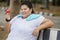 Happy obese woman holds an apple in the park