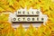 Happy October alphabet letter with maple leaves decoration on wooden background