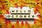 Happy October alphabet letter with maple leaves decoration on wooden background