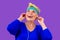 Happy old cheerful female and a blue bandage on forehead, listen yoga mantra meditation song on headphones.forever young