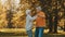 Happy old couple dancing in park. Senior man flirting with elderly woman. Romance at old age autumn day