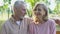 Happy old couple looking in camera, embracing, smiling satisfied with life